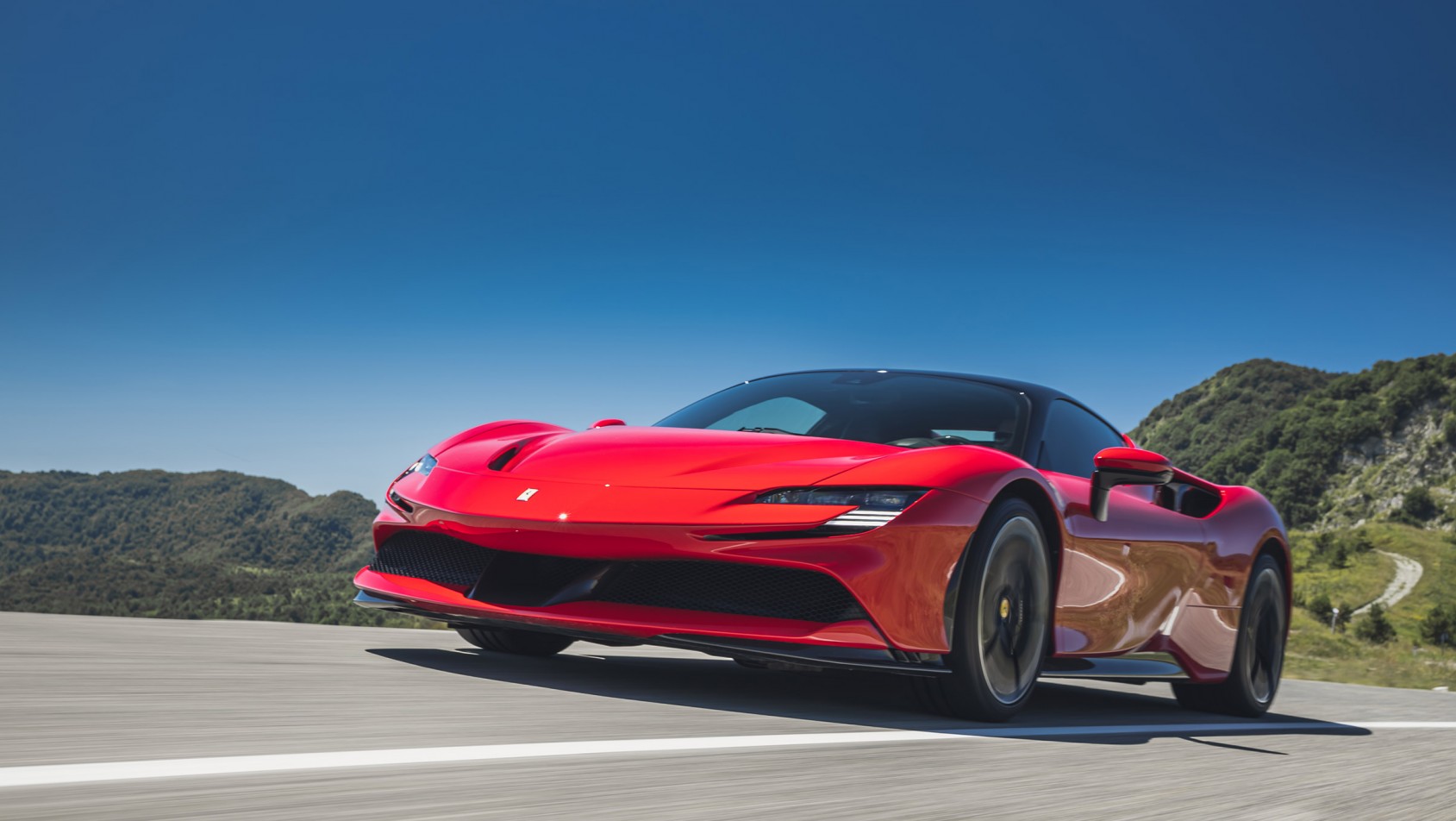 Czerwone Ferrari SF90 Stradale na drodze