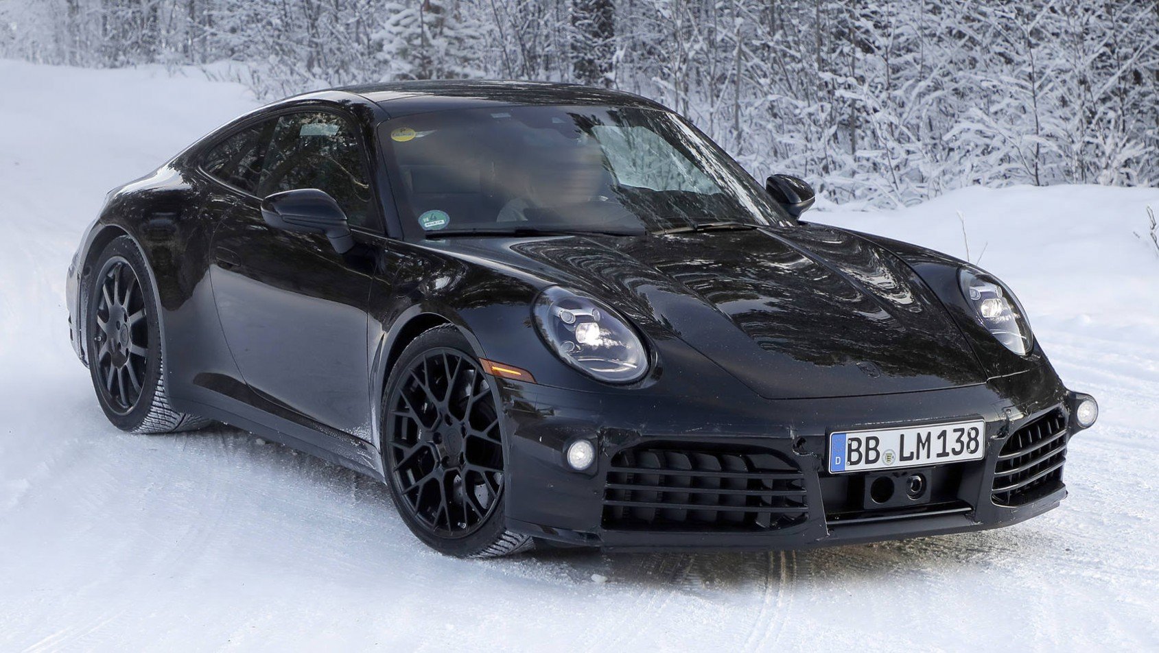 Czarne Porsche 911 generacji 992.2 na śniegu bok