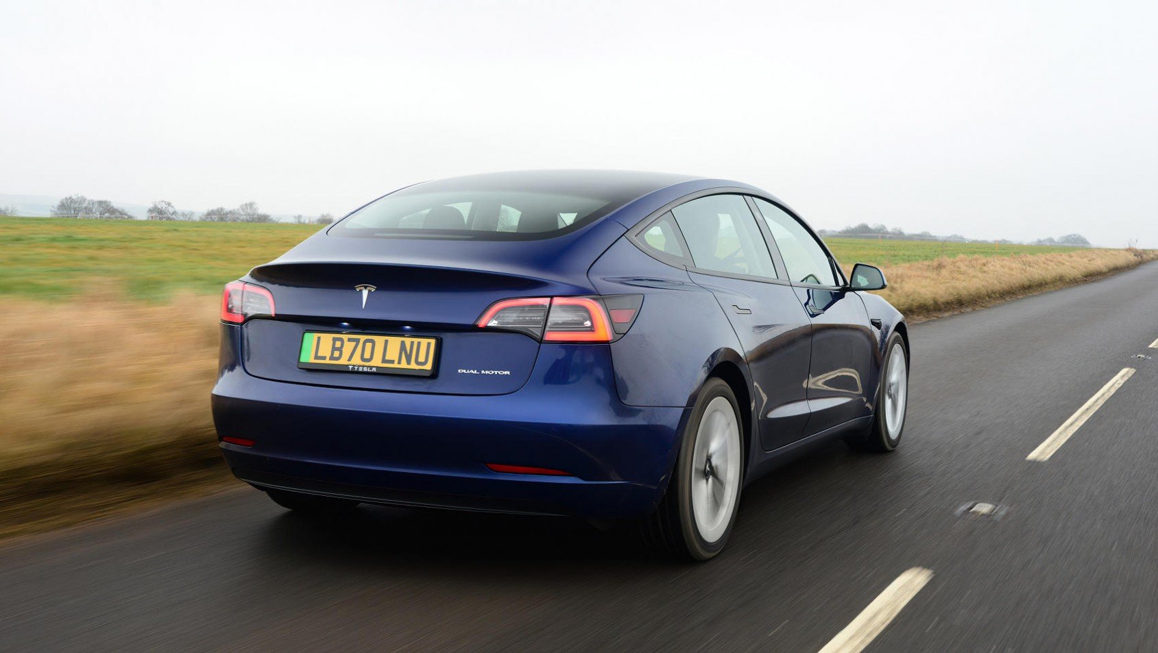 Tesla model 3 na drodze sylwetka z tyłu