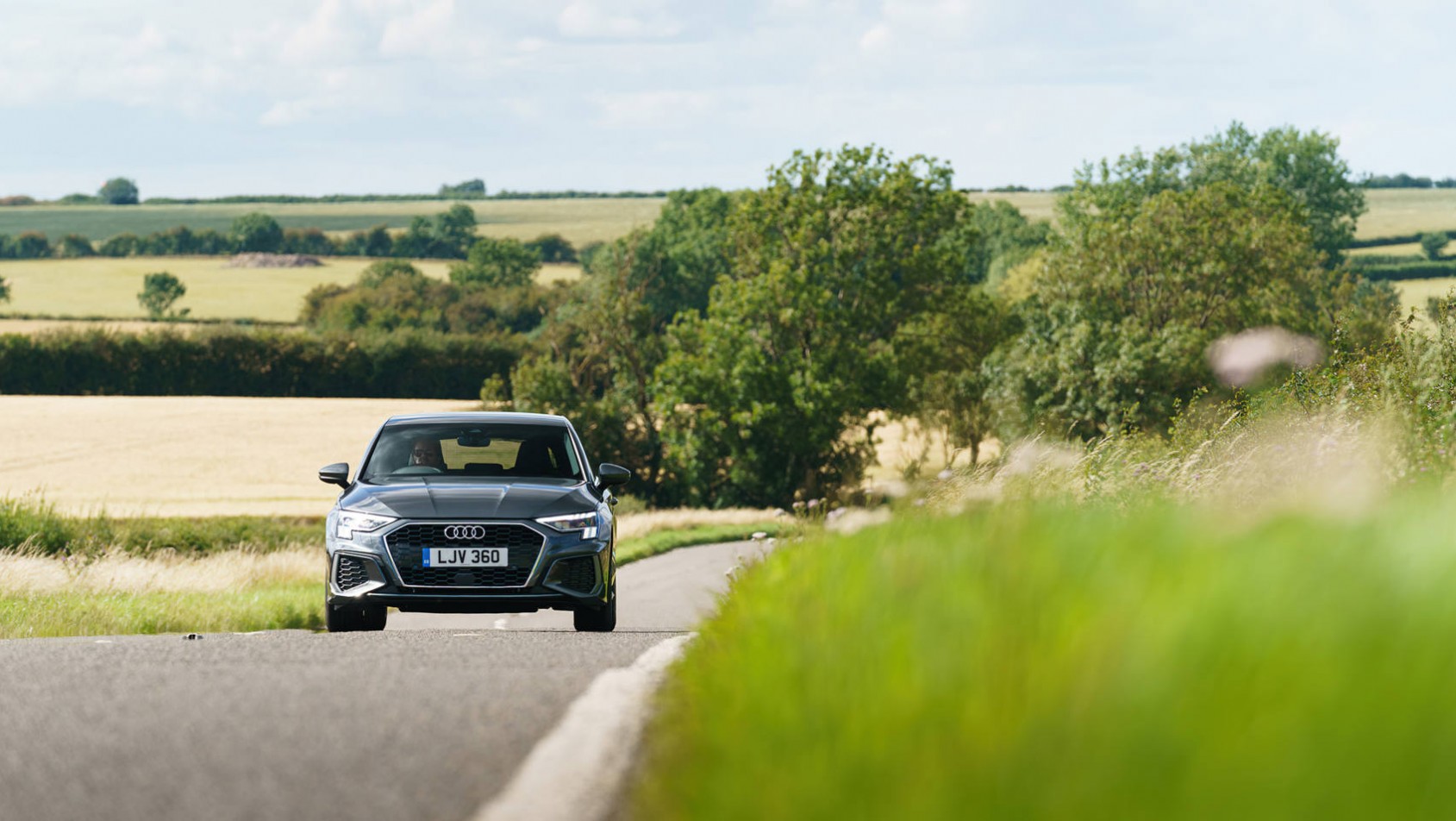 Audi A3 na podmiejskiej drodze wśród pól
