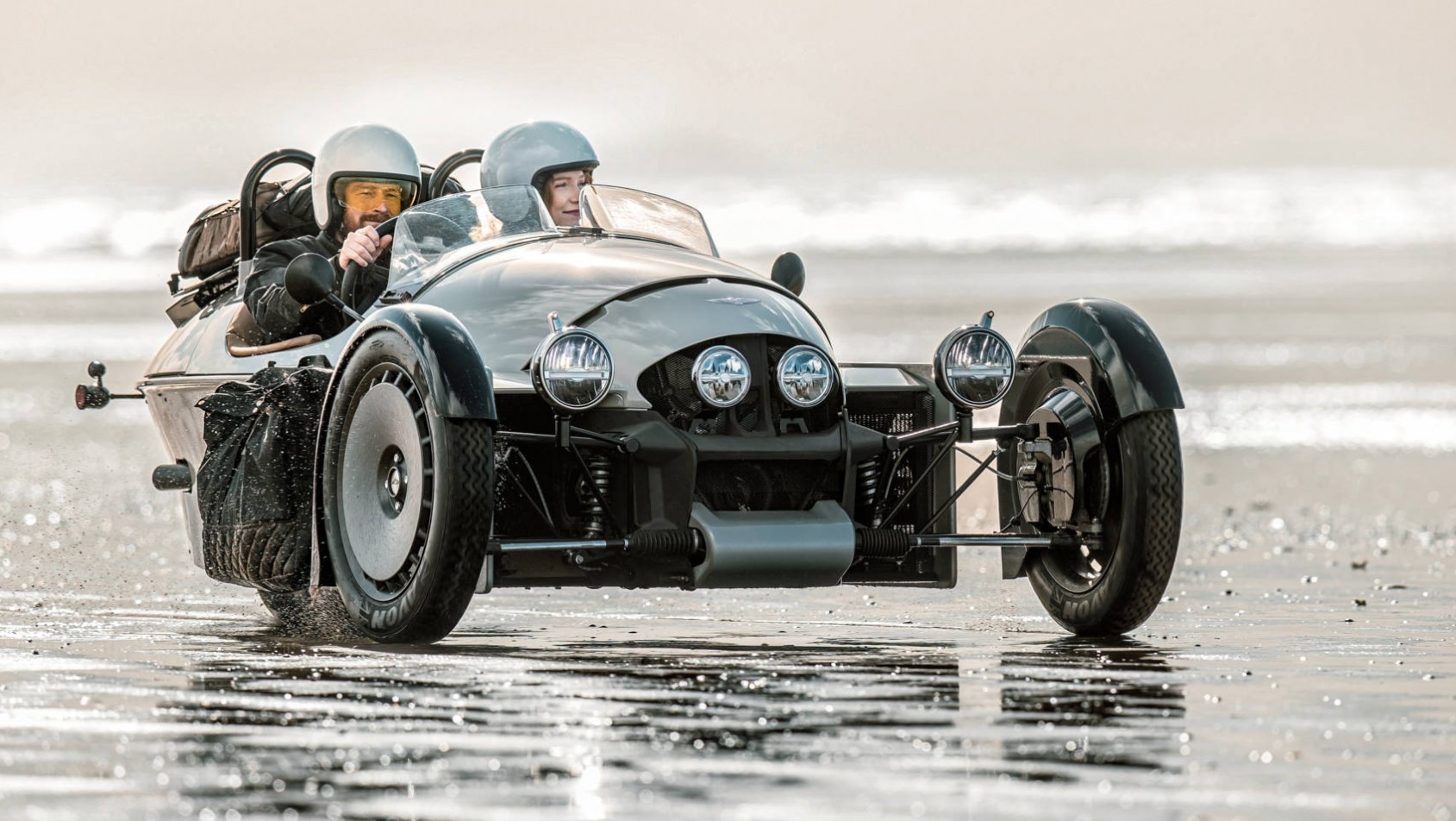 Nowy Morgan Super 3 para bawi się samochodem na plaży