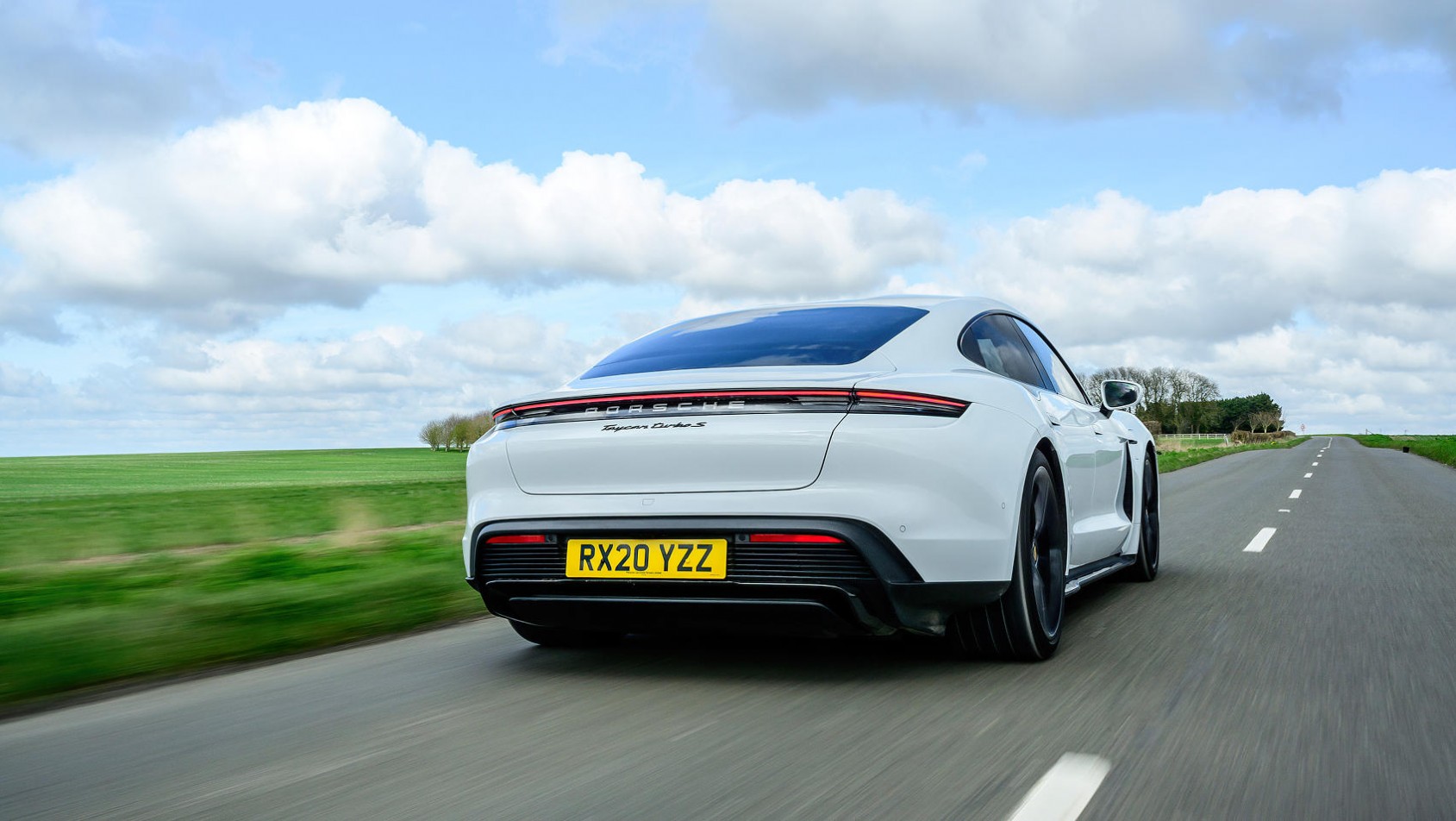 Porsche Taycan biały z tyłu na drodze