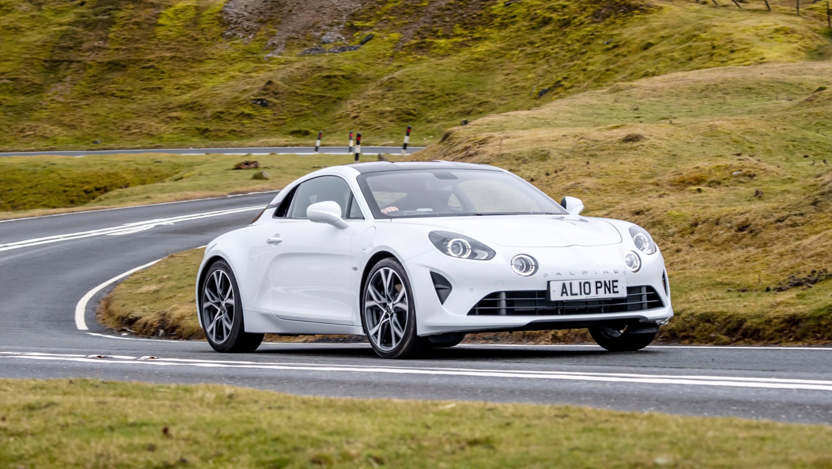 Alpine A110 białe na drodze za zakrętem