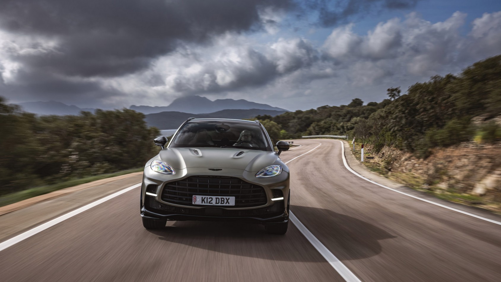 Aston Martin DBX707 na drodze na tle gór