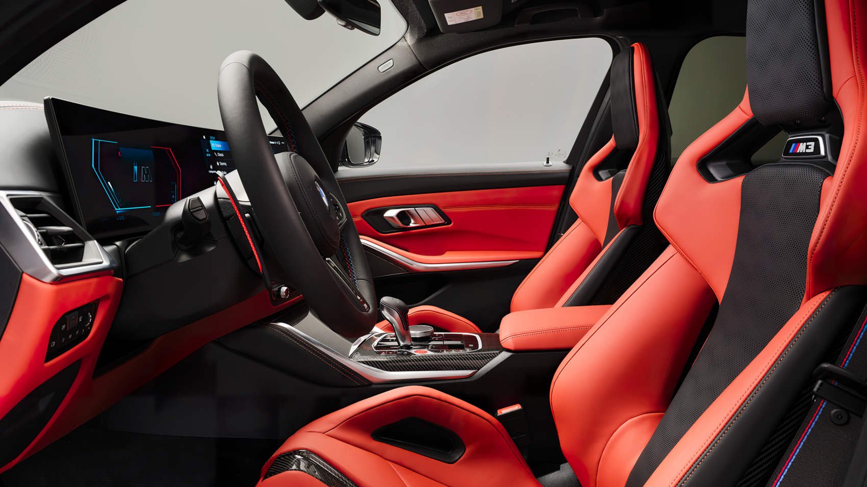BMW M3 Touring Competition xDrive - wnętrze z czerwonymi kubełkowymi fotelami