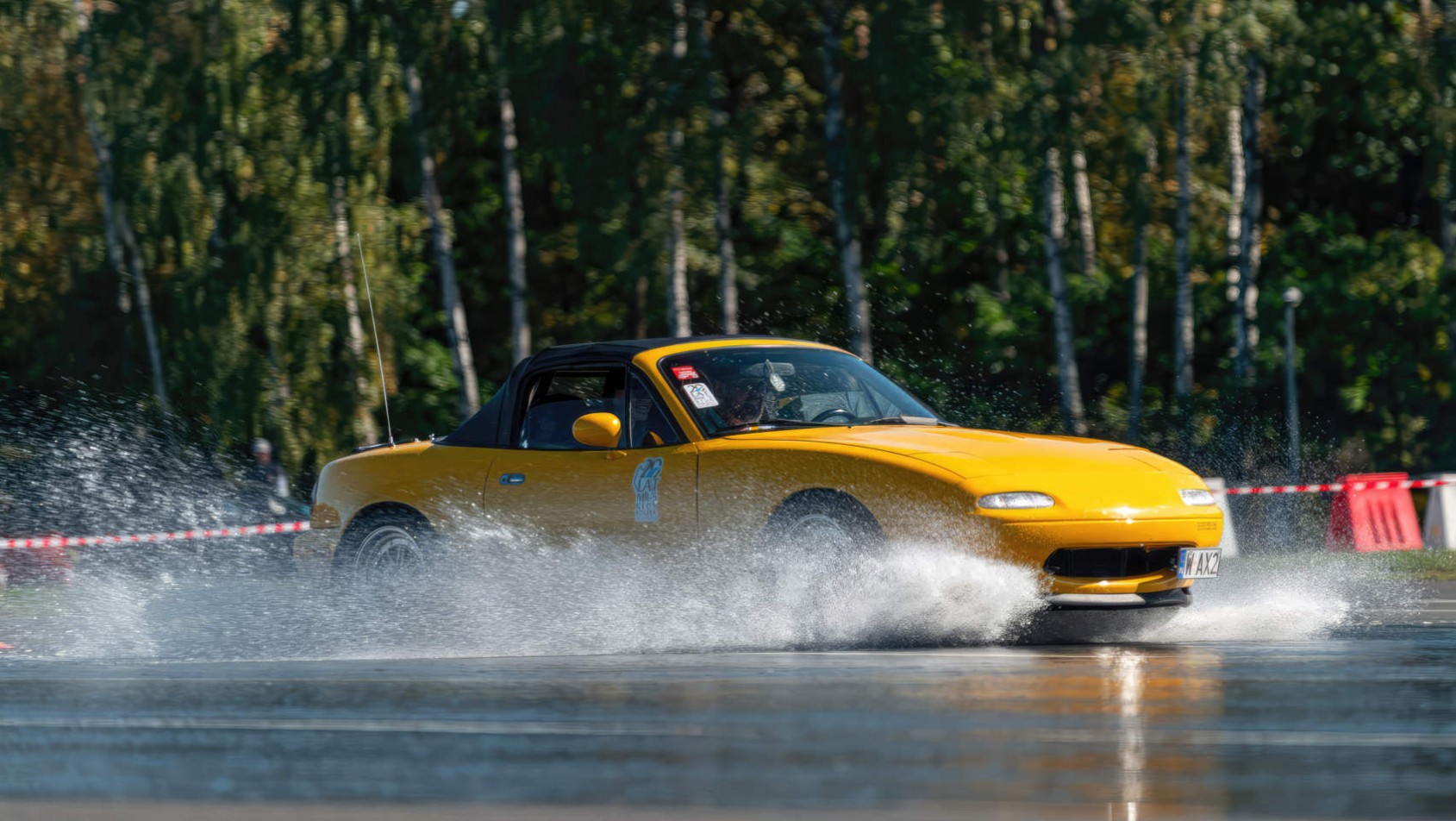Żółta Mazda MX-5 na mokrej nawierzchni