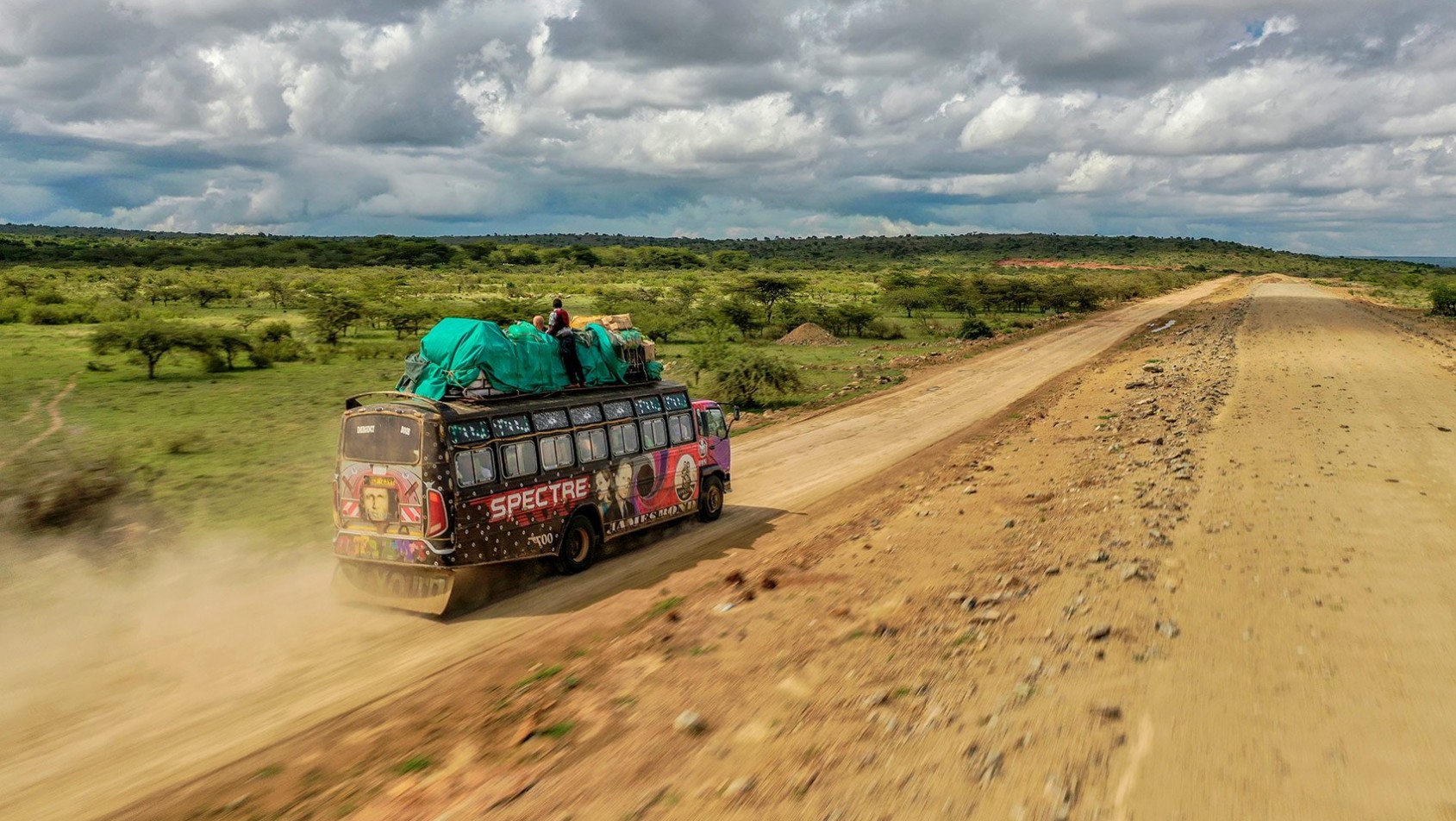 Kolumna samochodów terenowych pokonująca ośnieżoną drogę nocą, ujęcie z drona