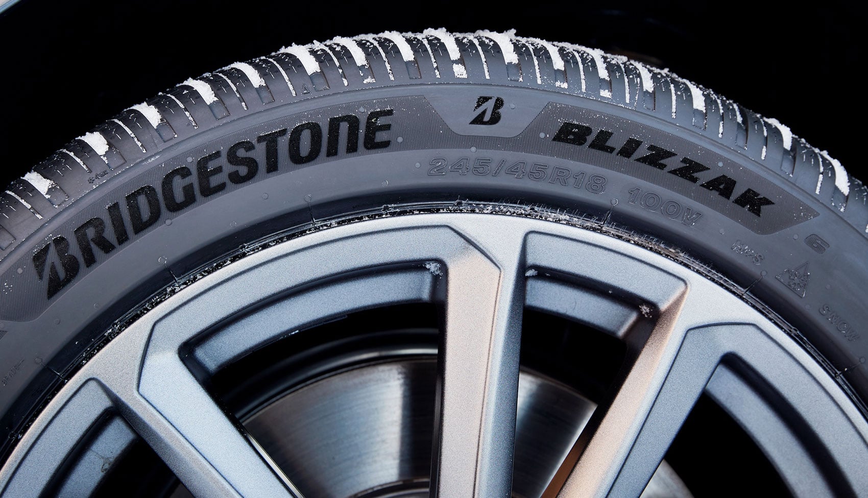 Bieżnik opony Bridgestone Blizzak 6 na aucie jadącym po zaśnieżonej drodze.