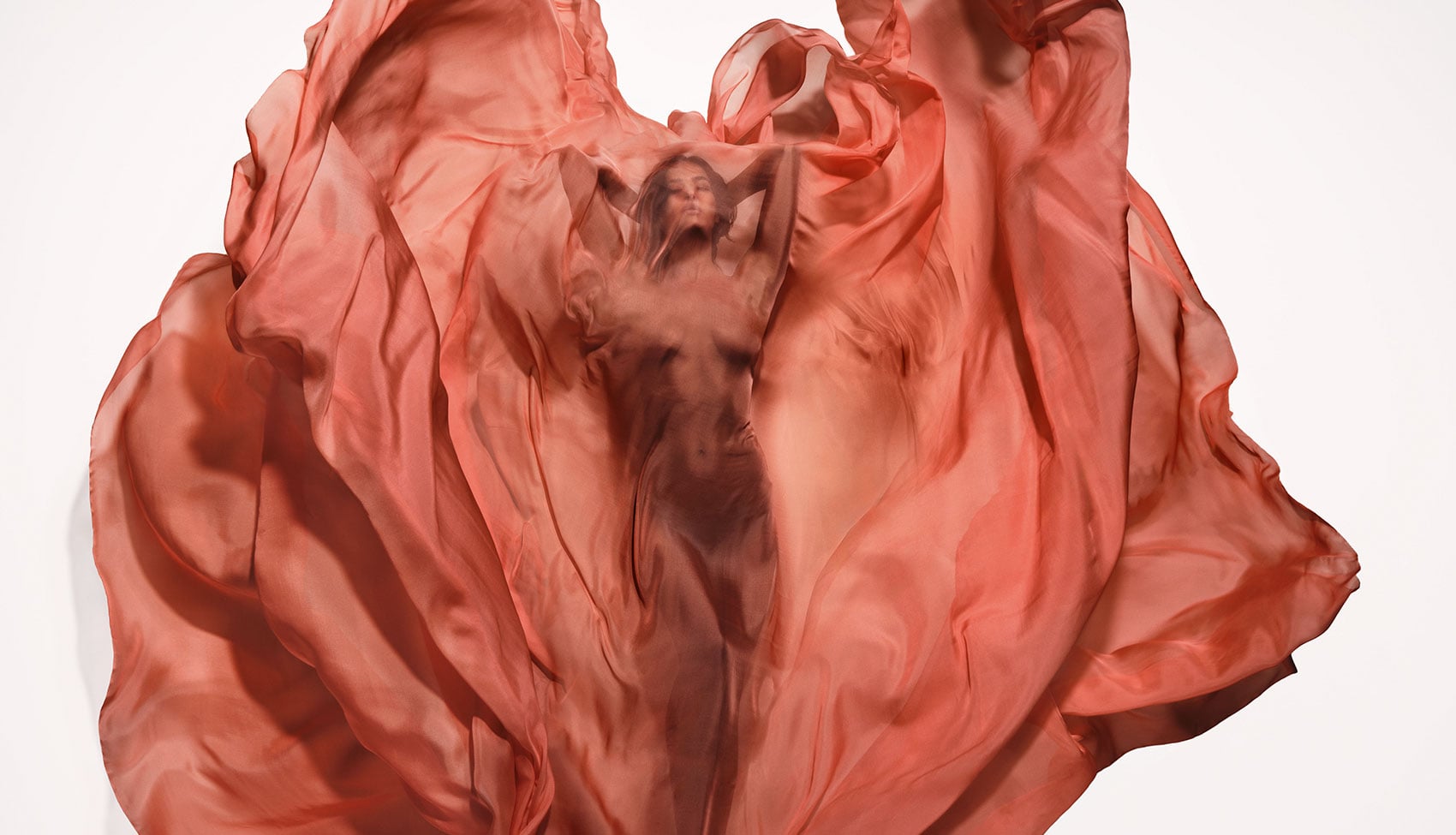 Irina Shayk – żywioł ognia w projekcie Pirelli Calendar 2026 Irina Shayk otulona falującą czerwoną tkaniną w dynamicznej interpretacji żywiołu ognia