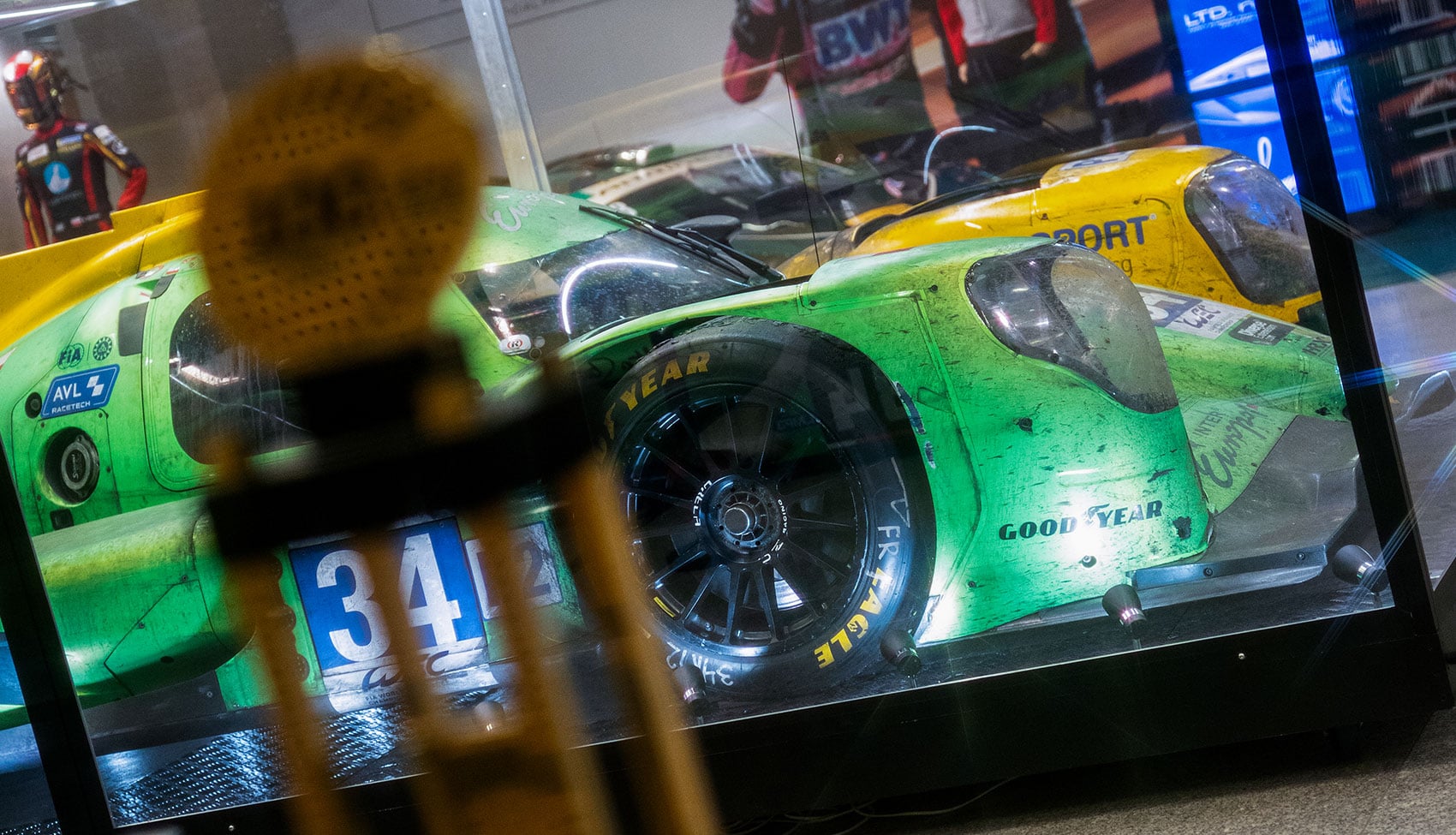 Prototyp wyścigowy Inter Europol Competition po 24h Le Mans na Wystawie Castrol Ikony Motoryzacji Zielono-żółty prototyp wyścigowy Inter Europol Competition po 24h Le Mans, pokryty śladami rywalizacji, prezentowany w gablocie na Wystawie Castrol Ikony Motoryzacji