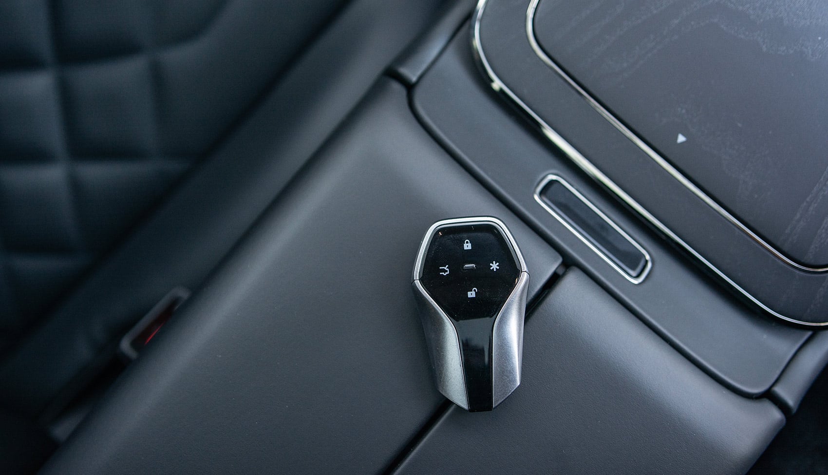 Zbliżenie na kluczyk GAC Hyptec HT leżący przy konsoli środkowej obok ekranu