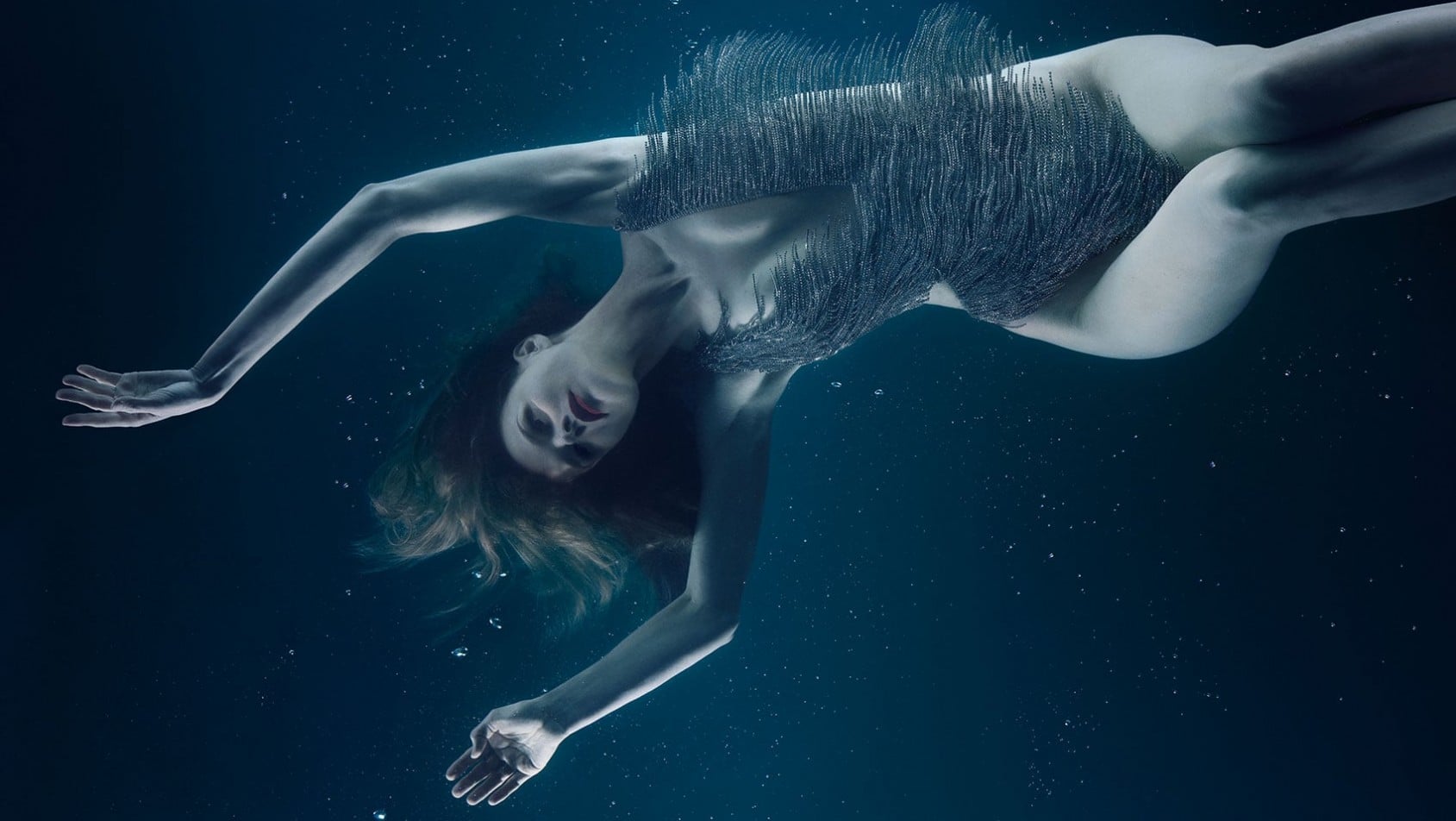 Eva Herzigová unosząca się pod wodą w eterycznej pozie, przedstawiona jako interpretacja żywiołu wody