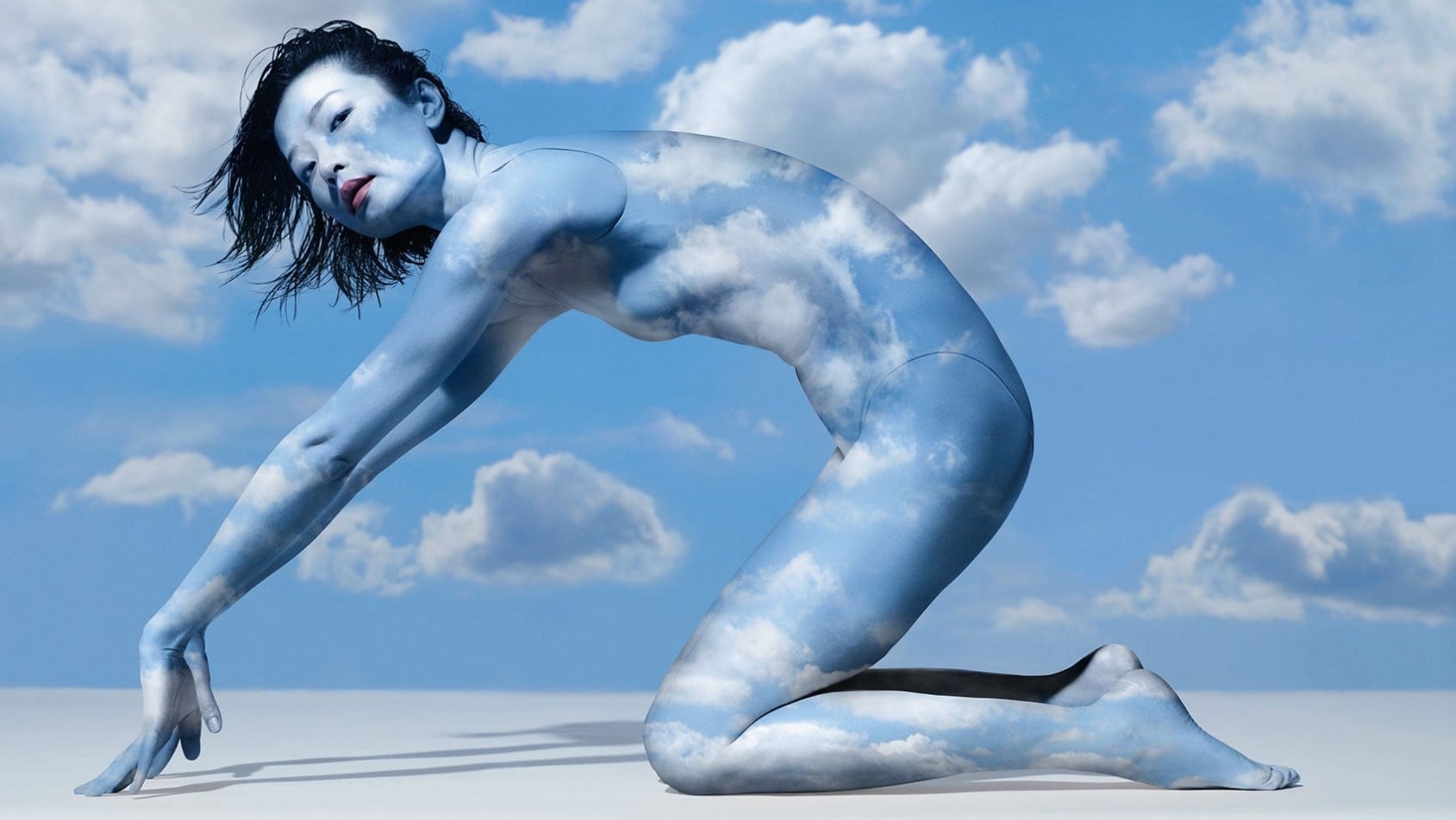 Du Juan w bodypaintingu przypominającym niebo i chmury, w artystycznej pozie symbolizującej żywioł powietrza