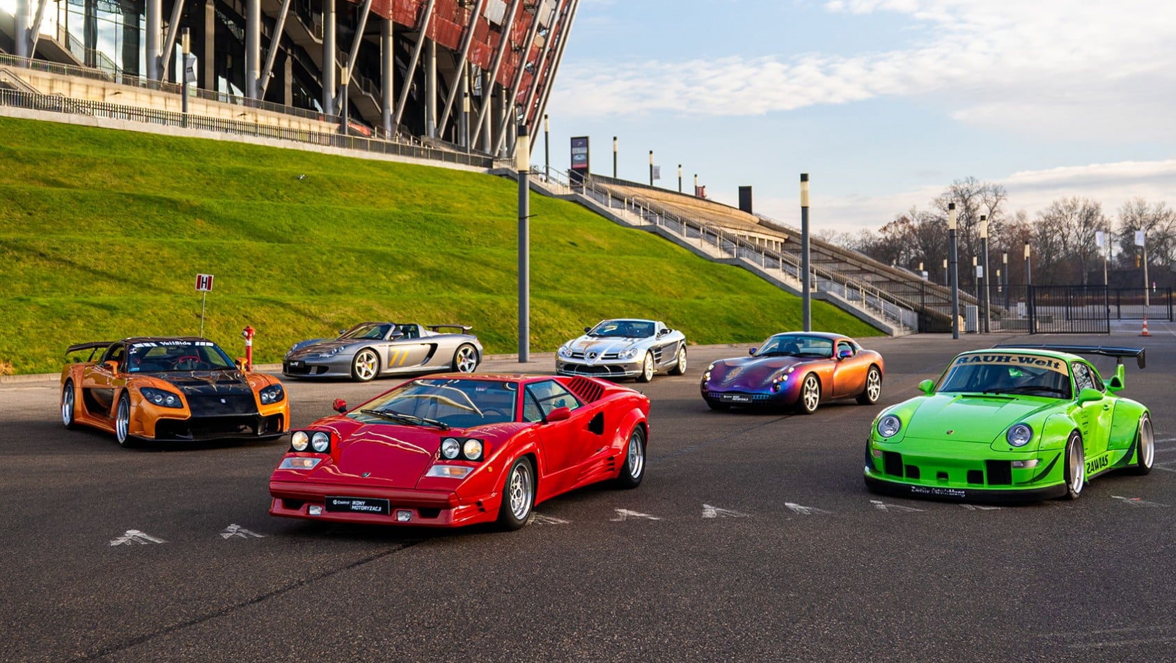 Lamborghini Countach, TVR Tuscan, Porsche Carrera GT, Mercedes SLR McLaren oraz RWB Porsche ustawione przed PGE Narodowym na otwartej przestrzeni