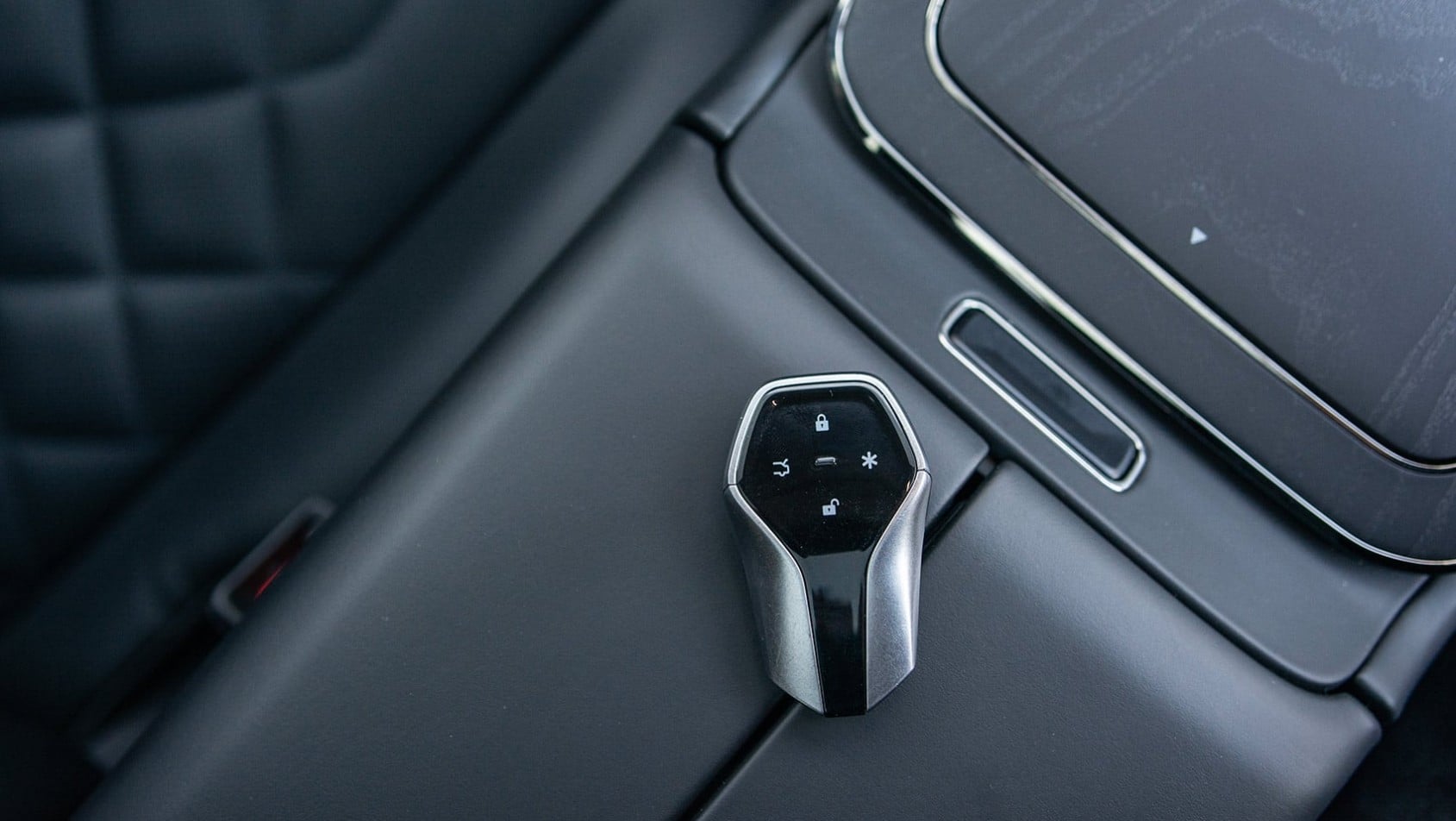 Zbliżenie na kluczyk GAC Hyptec HT leżący przy konsoli środkowej obok ekranu