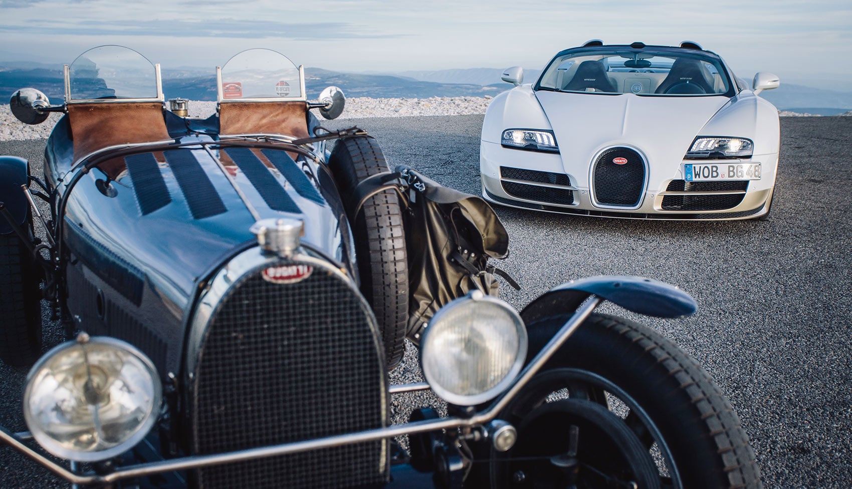 Klasyczne Bugatti i&nbsp;nowoczesne Bugatti zaparkowane na&nbsp;górskiej przełęczy