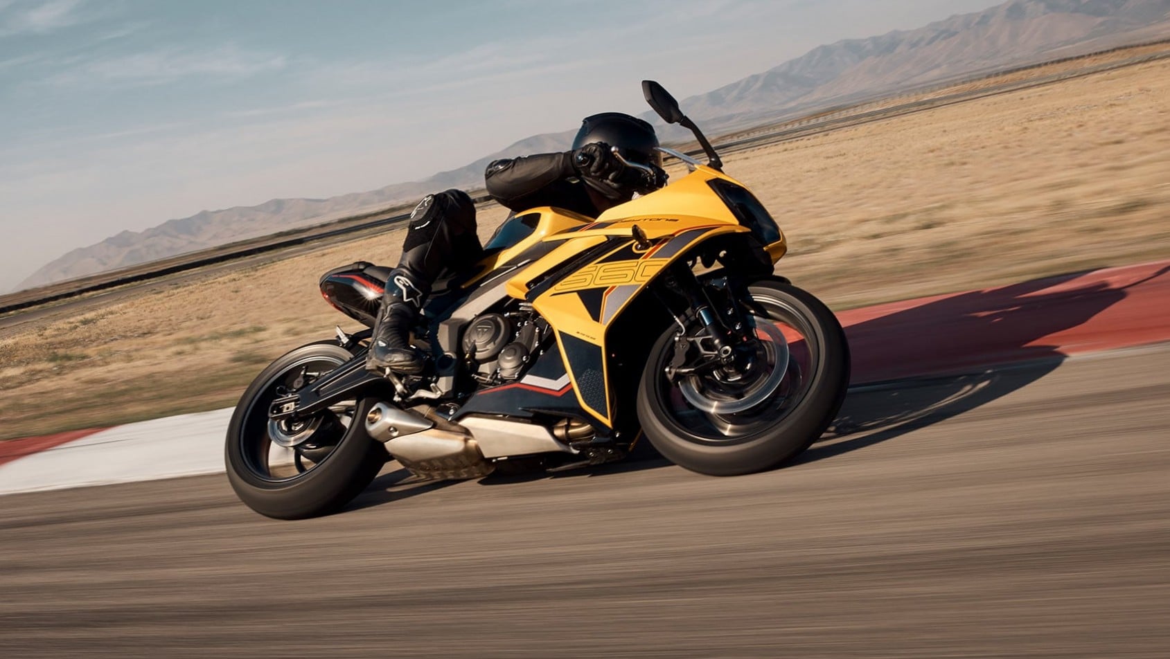 Motocykl Triumph Daytona 660 2026 dynamicznie pokonujący zakręt na torze, widok z boku