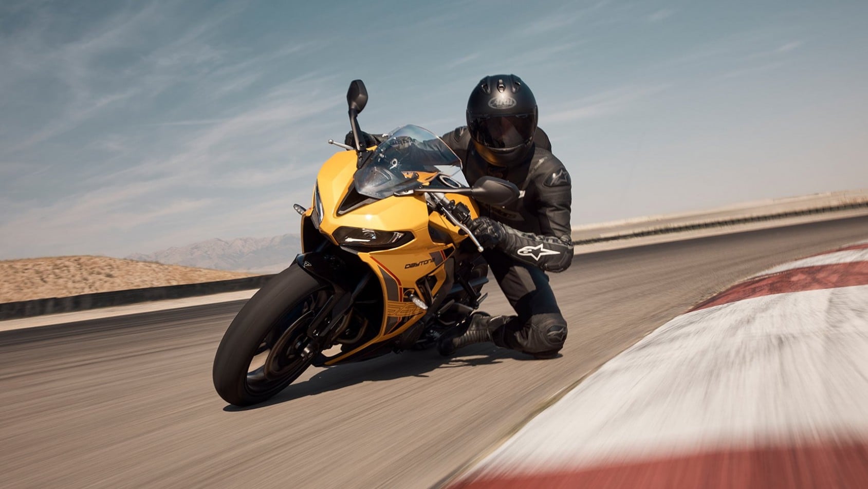 Triumph Daytona 660 2026 w kolorze żółtym podczas jazdy po torze wyścigowym, złożenie w zakręcie