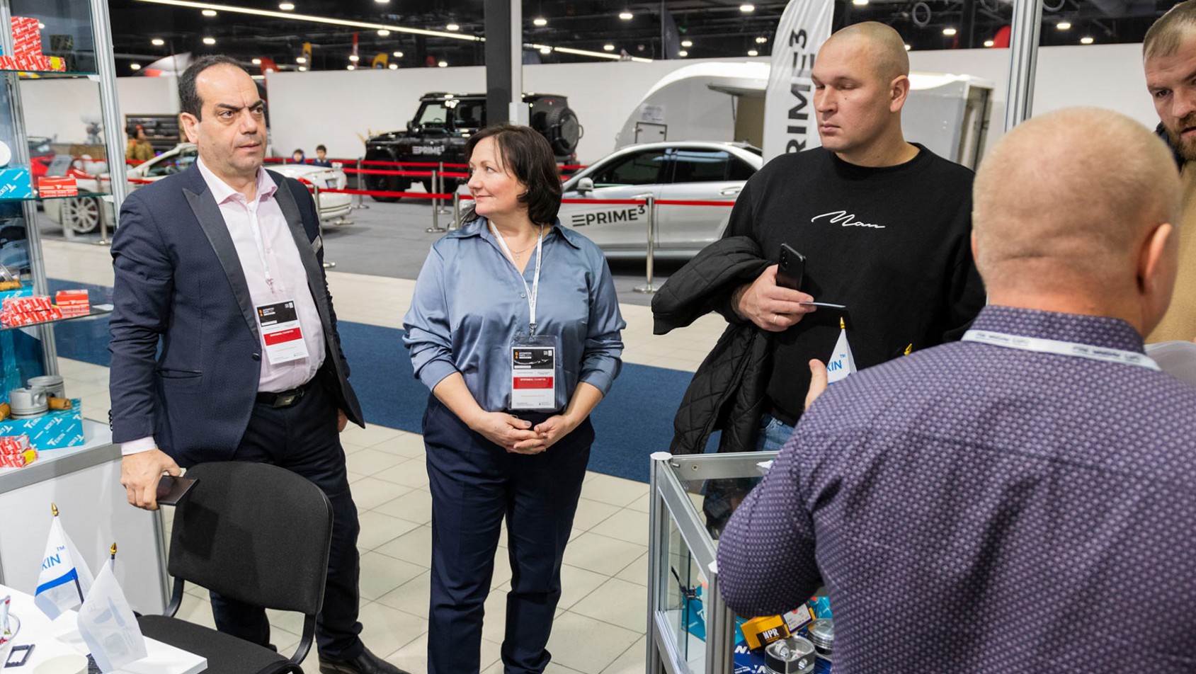 Wystawcy i odwiedzający rozmawiają przy stoisku podczas Auto Tuning Show w Ptak Warsaw Expo