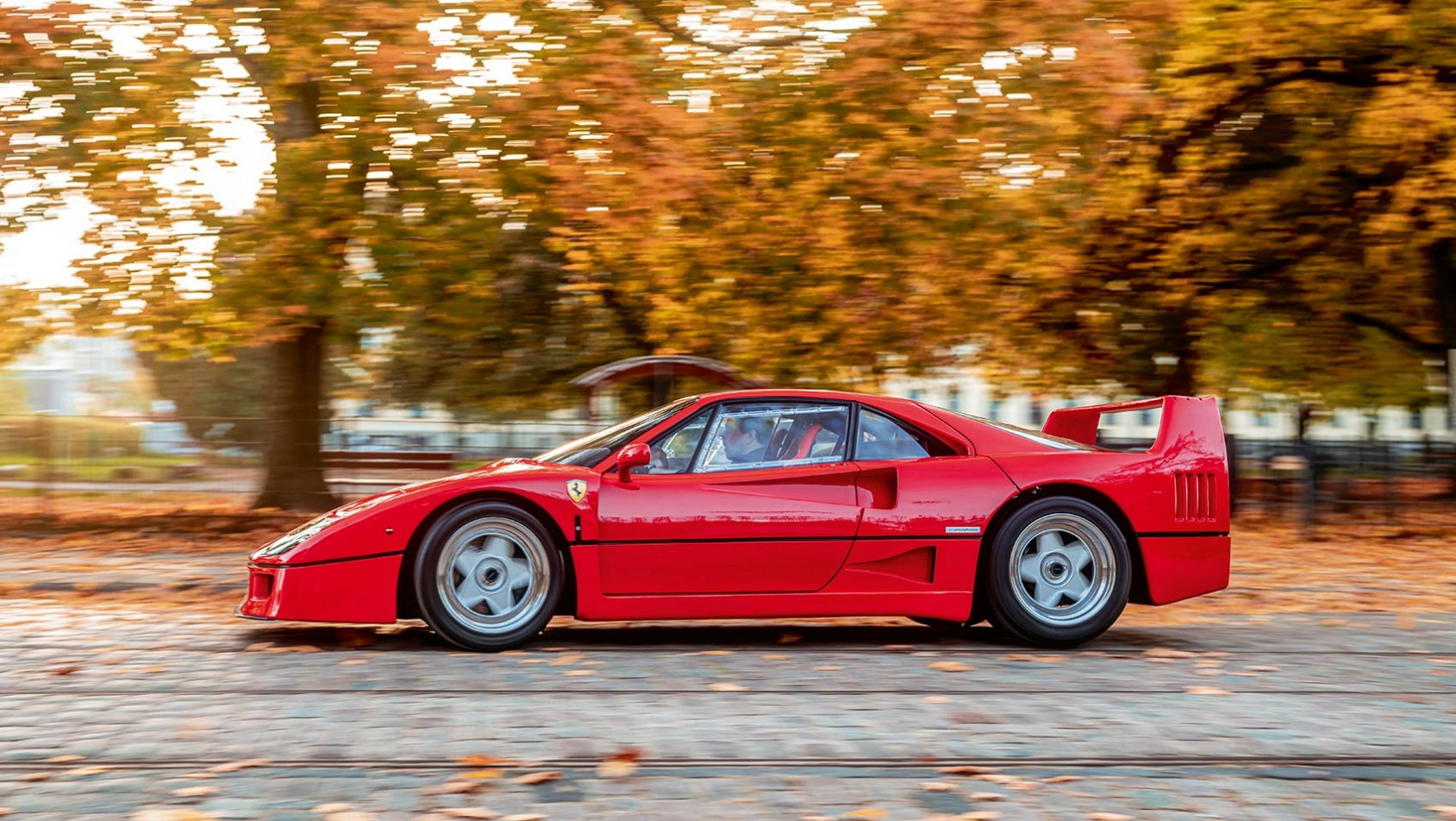 Ferrari F40 w ruchu na tle jesiennych drzew