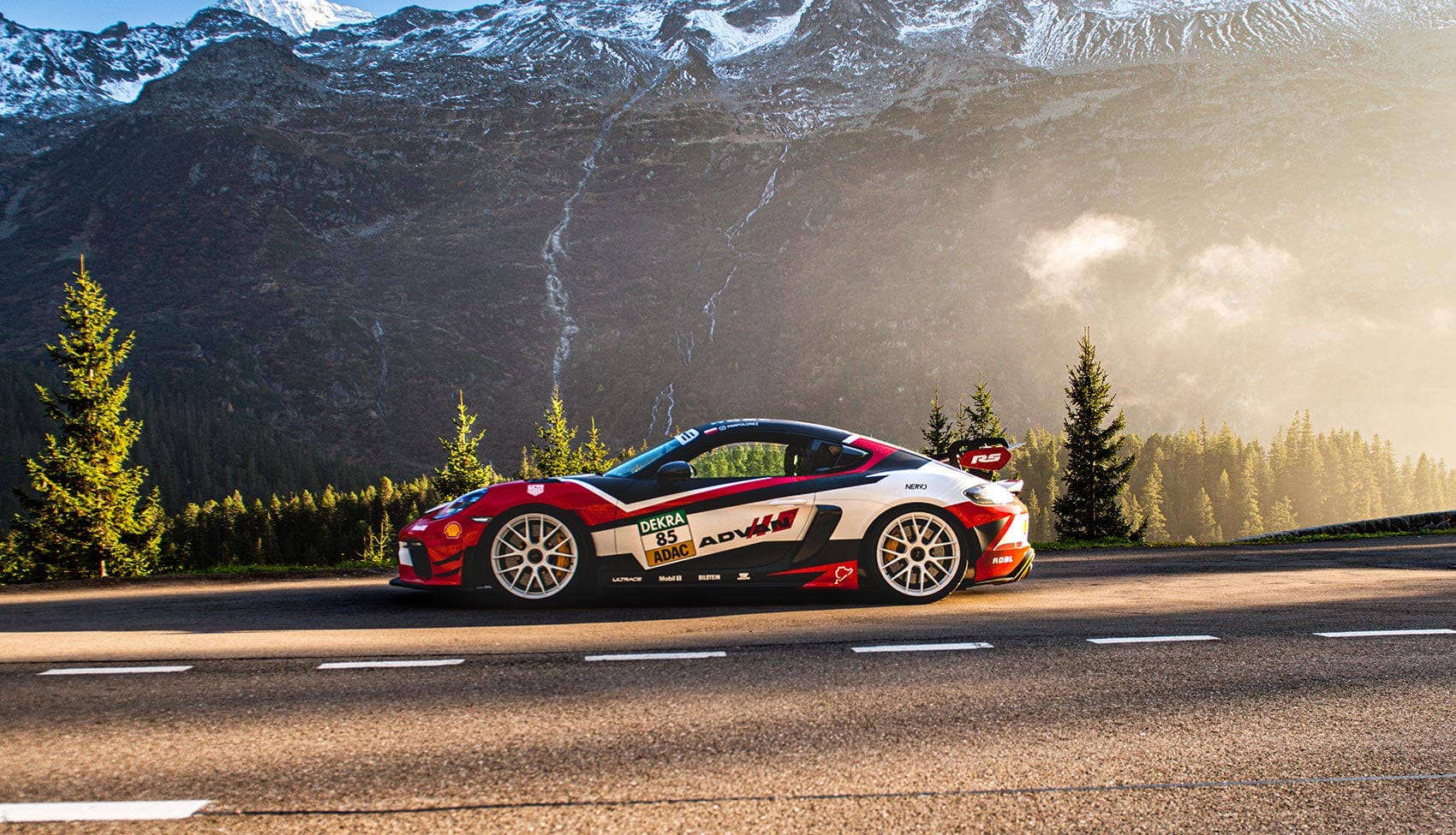 Porsche Cayman GT4 RS na&nbsp;alpejskiej drodze otoczonej wysokimi szczytami Szwajcarii