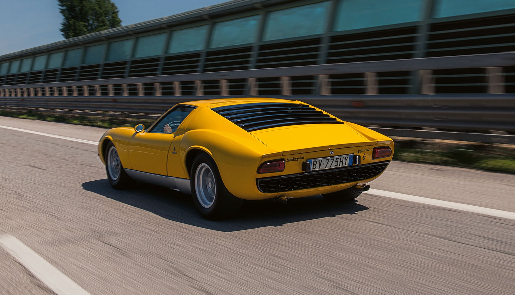 Żółte Lamborghini Miura P400 S jadące drogą