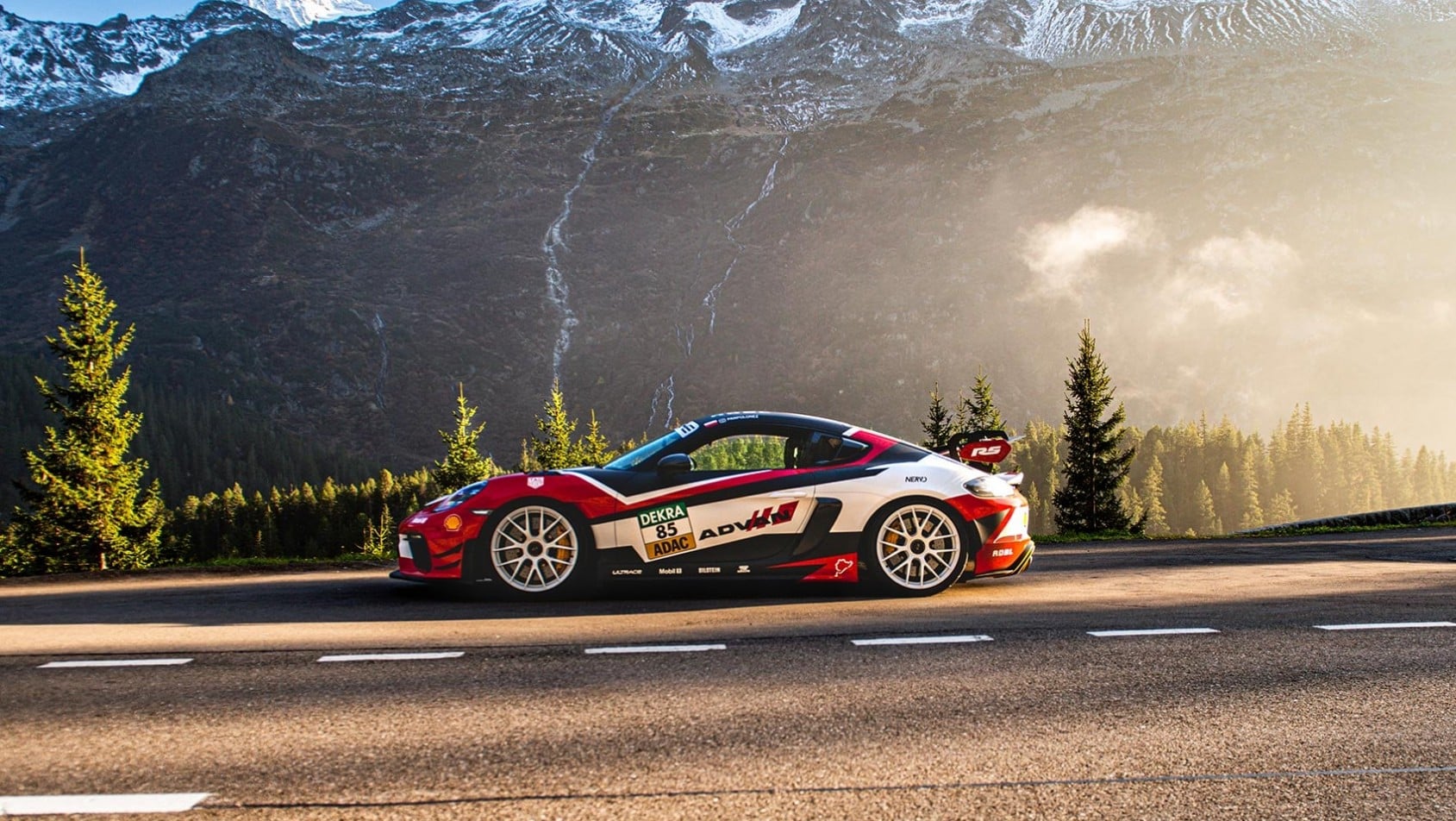 Porsche Cayman GT4 RS na alpejskiej drodze otoczonej wysokimi szczytami Szwajcarii
