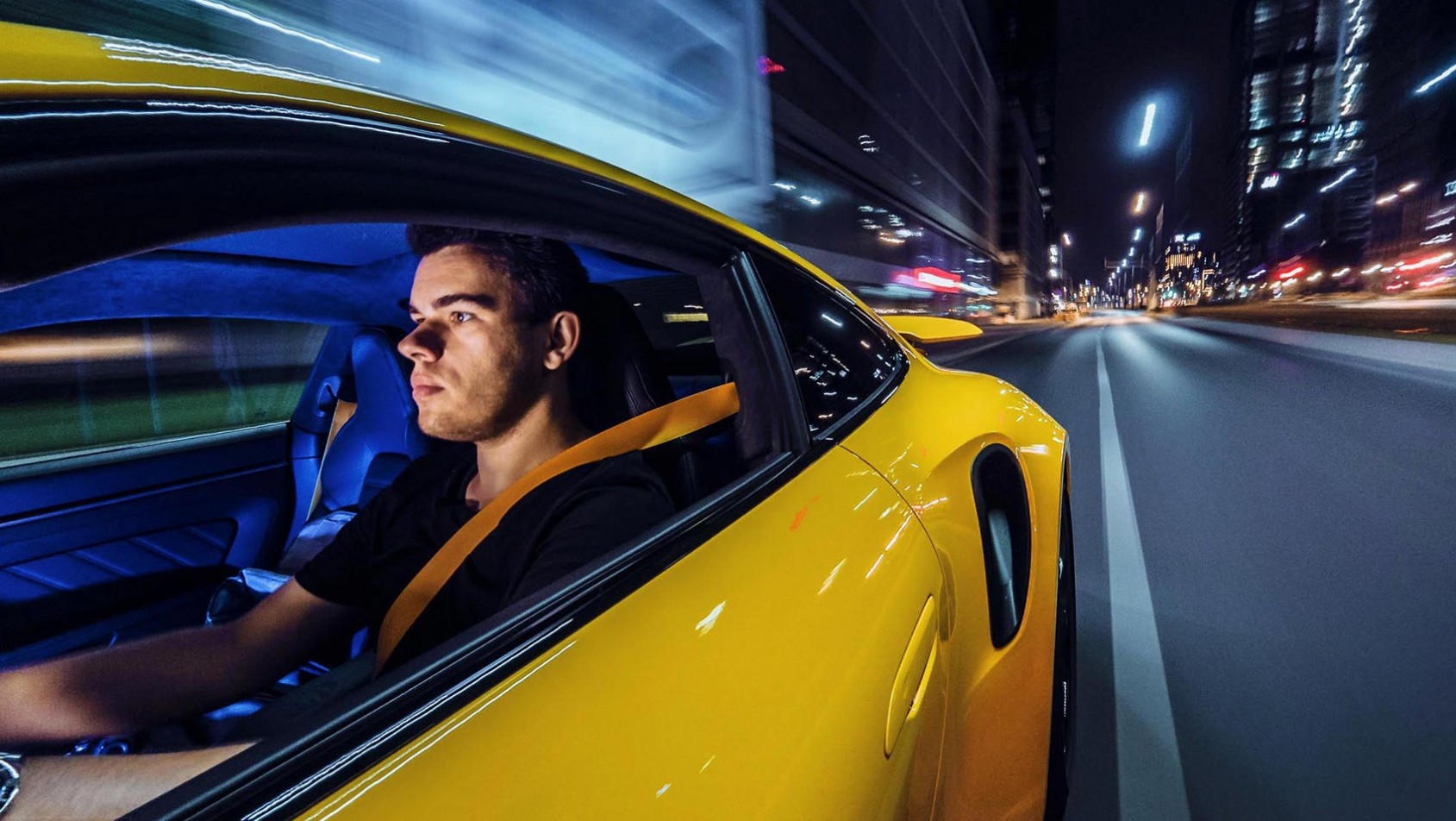Konrad Skura w sportowym samochodzie podczas nocnej sesji fotograficznej