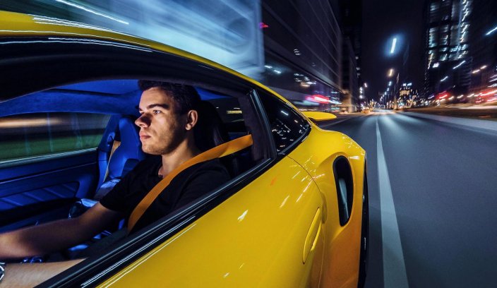 Konrad Skura w sportowym samochodzie podczas nocnej sesji fotograficznej